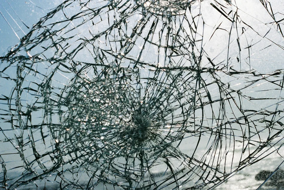 Close view of impact damage and cracks in a windshield